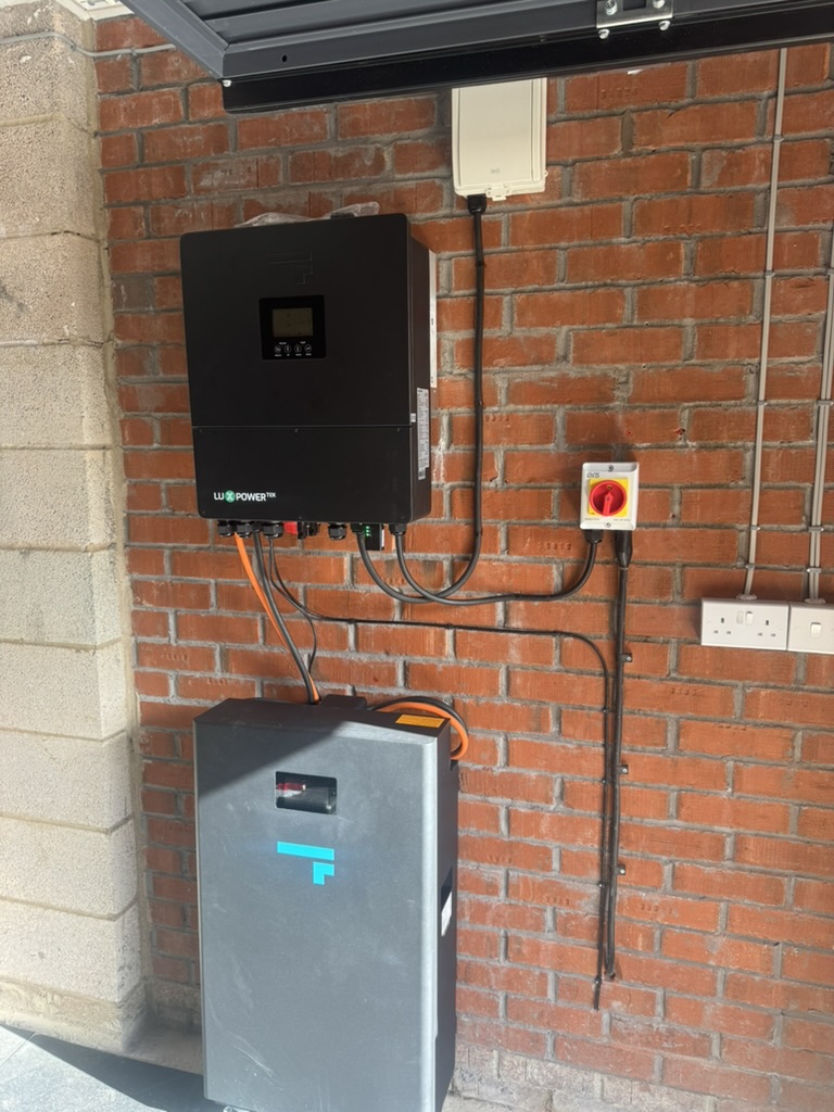 LuxPower inverter and home battery installed on a brick garage wall with electrical isolation equipment